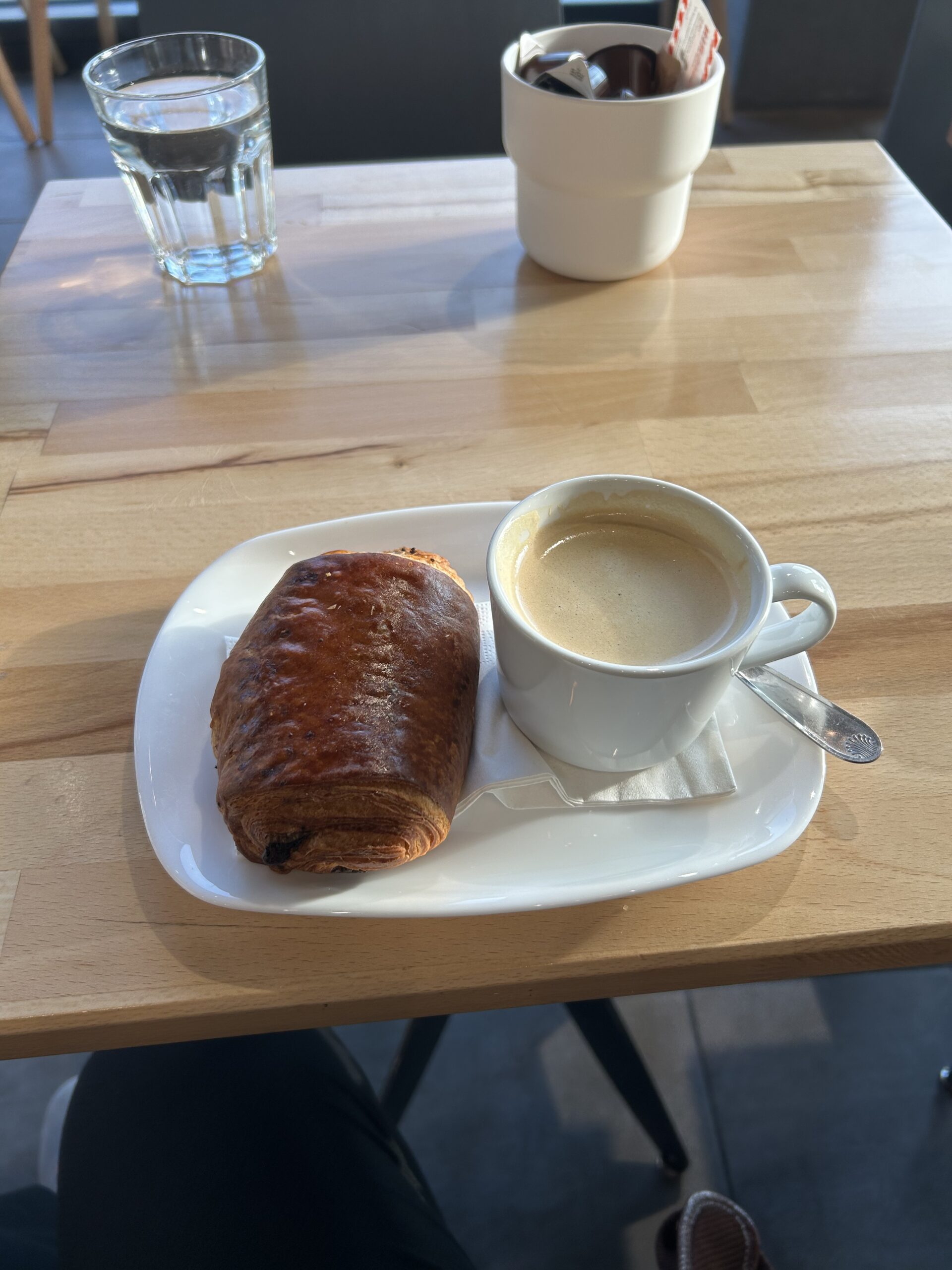 A chocolate croissant and cup of coffee